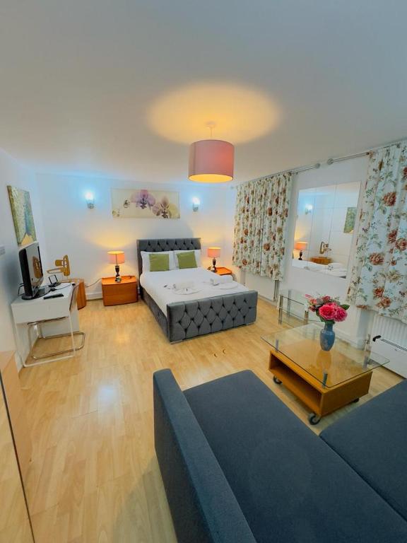 a large living room with a bed and a couch at Bright Budget Studio Apartment In Central London in London