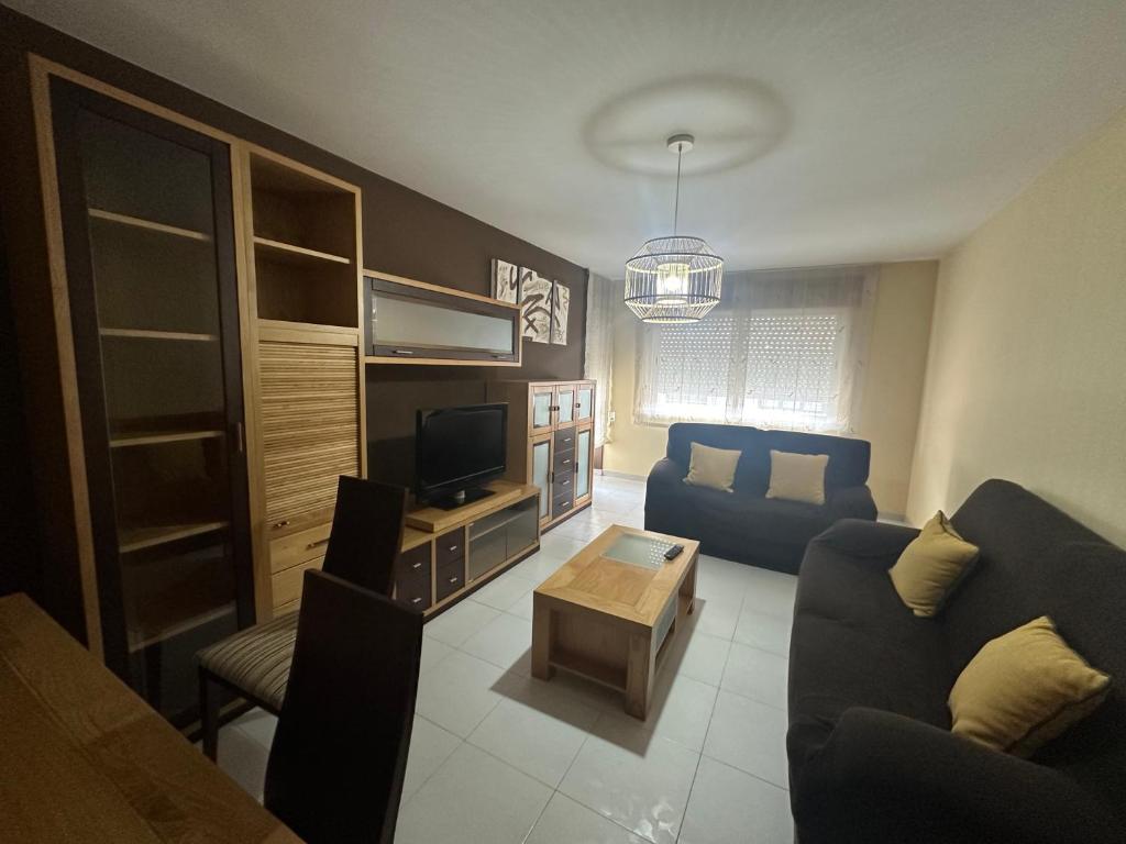 Una sala de estar con un sofá y un televisor. en HOME GV35 By Oktheway, en Sarria