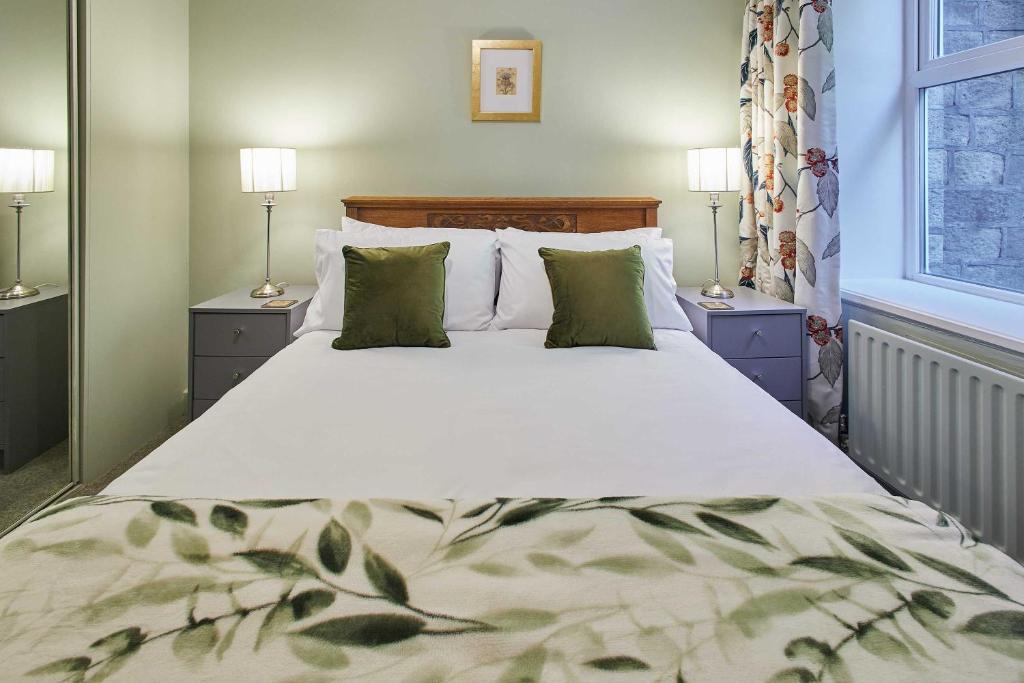 Host & Stay - Ormesby في Greetland: سرير كبير في غرفة النوم ومصباحين