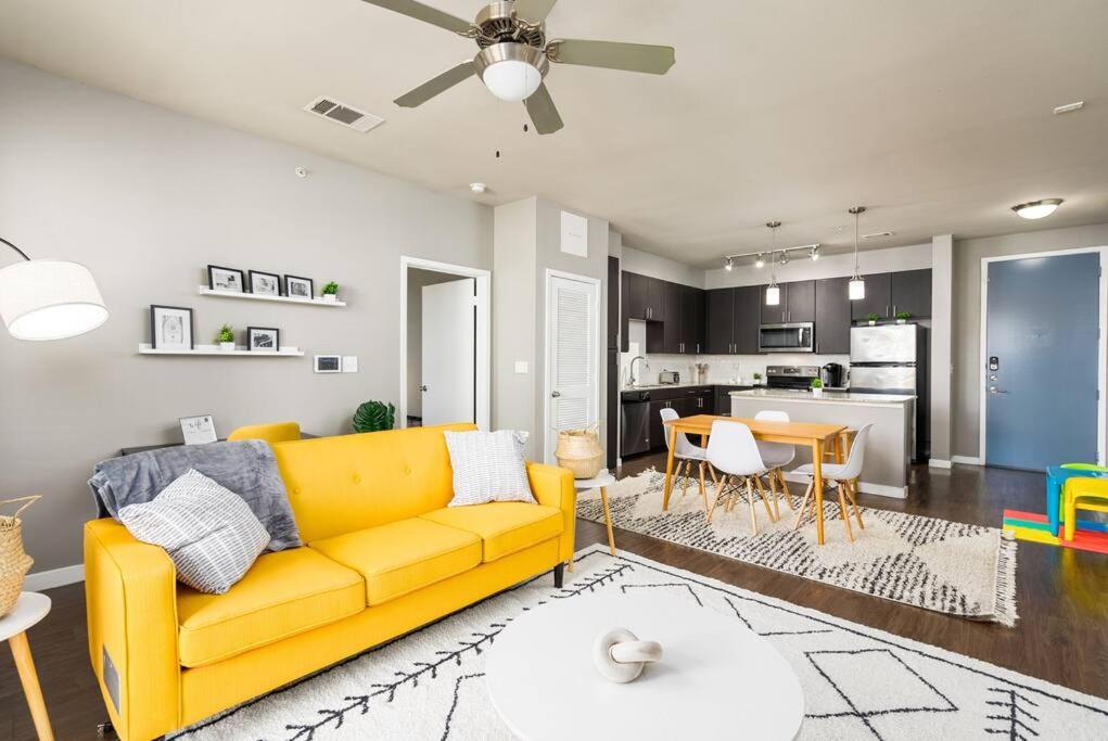 a living room with a yellow couch and a kitchen at Chic King Bed Desk w/ Pool in San Antonio