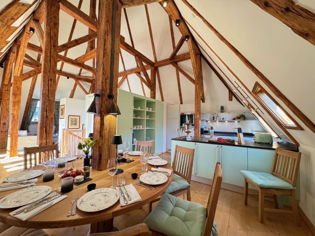 a dining room with a wooden table and a kitchen at TURM KAPS Luxury home direkt am Golfplatz by Belle Stay in Kitzbühel