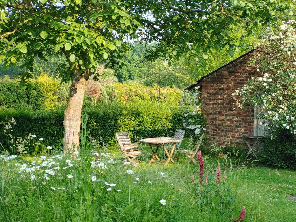 une table et des chaises au milieu d'un jardin dans l'établissement Gerritz+Gäste, à Meerbusch