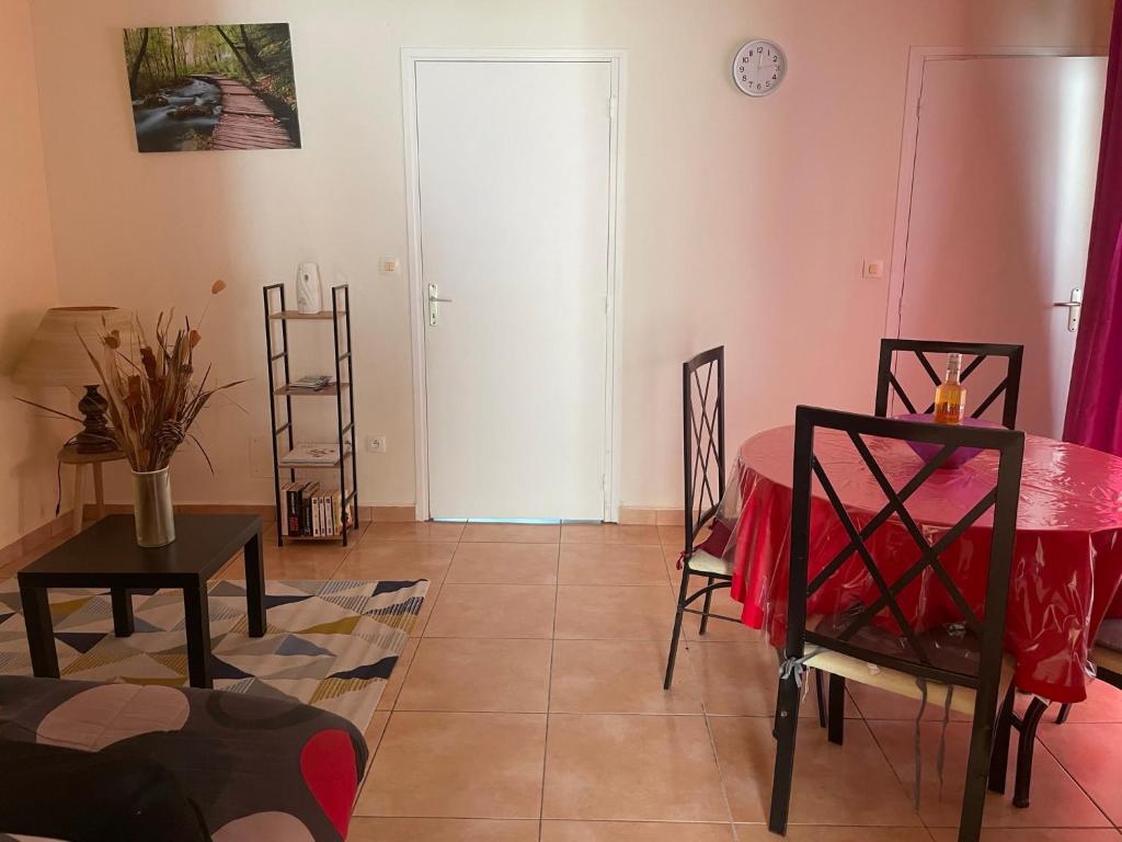 ein Wohnzimmer mit einem Tisch und einer Tür in der Unterkunft Appartement Hibiscus in Basse-Terre