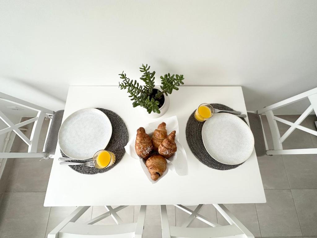 una mesa blanca con huevos y cruasanes. en Jaukūs apartamentai Šilutėje en Šilutė