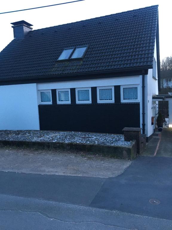 ein weißes Haus mit schwarzem Dach und Fenstern in der Unterkunft My vintage Home in Solingen