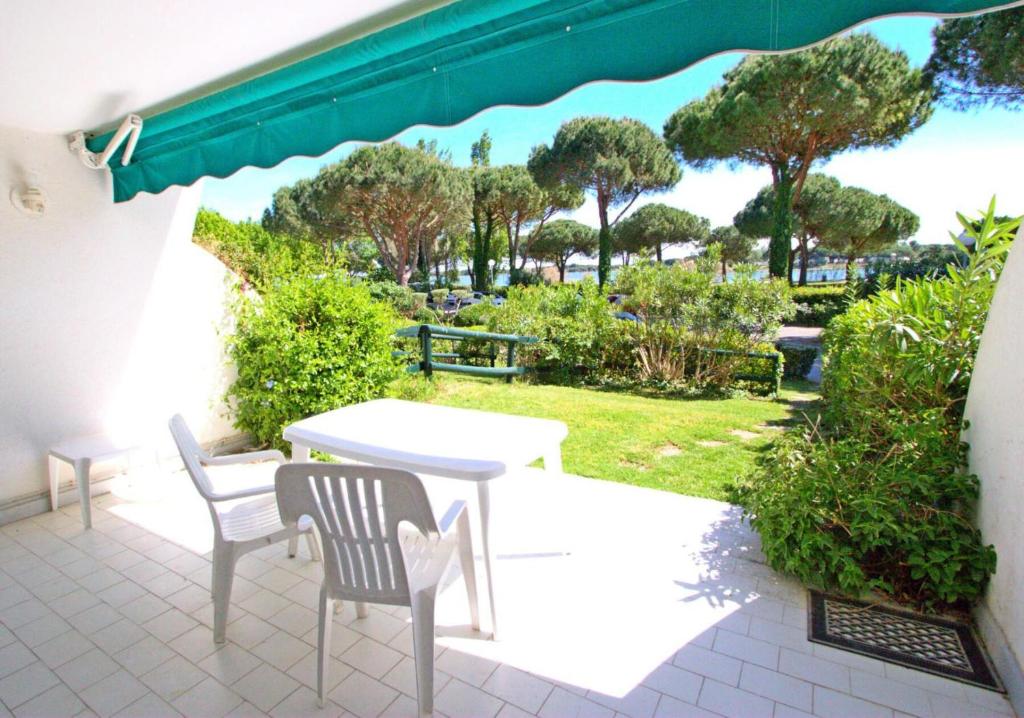 d'une terrasse avec une table et des chaises et une vue sur un parc. dans l'établissement Villegiales Tee2 - Bel appartement en rez-de-jardin vue Ponant MAE-1144, à La Grande Motte