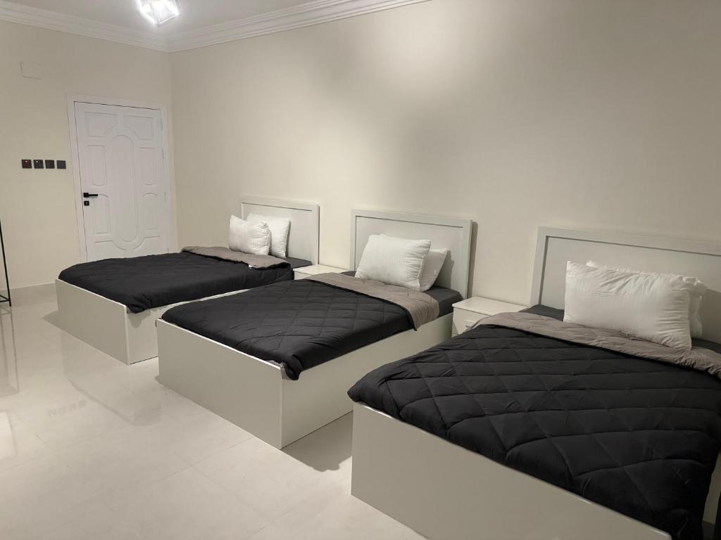 2 camas en una habitación blanca con faldas en Almansour Laxury Apartement, en Medina