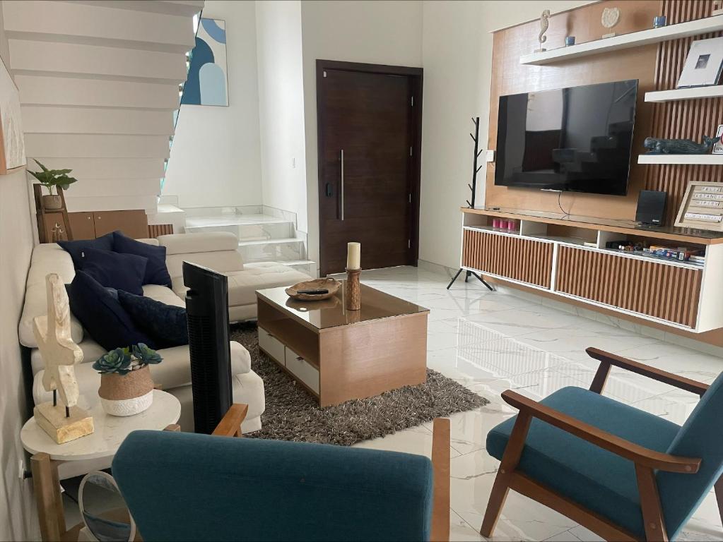 a living room with a couch and a tv at Casa Santacruz in Ensenada