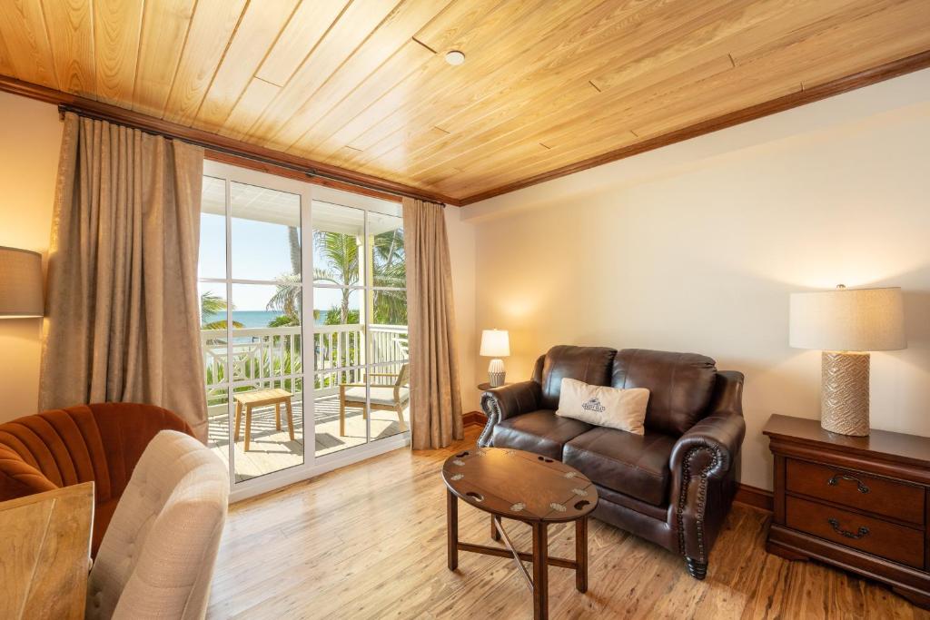 a living room with a leather couch and a table at Grassy Flats Resort & Beach Club in Marathon