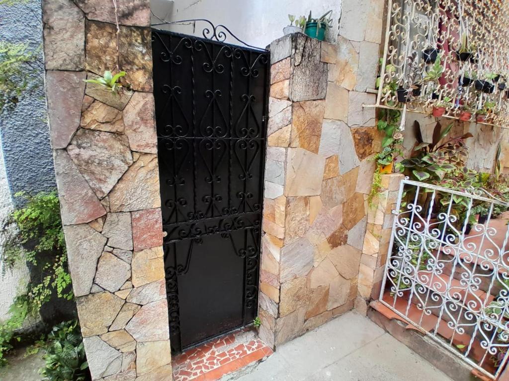 una puerta negra en un lado de una casa en Quarto em Villa Jardim Botânico, en Río de Janeiro