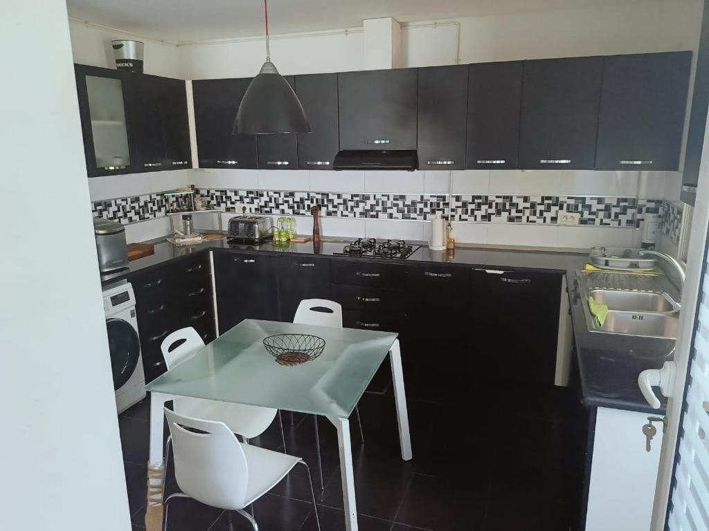 a kitchen with a small table and chairs in it at Amazing villa next to the beach in Nabeul