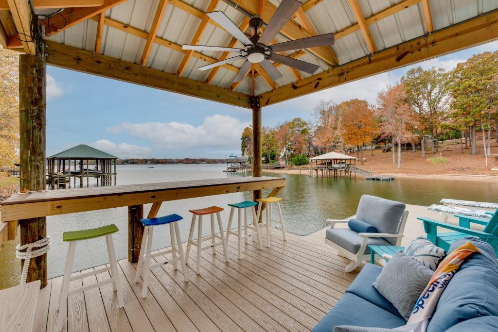 een groot terras met stoelen en een bar en water bij Cheerful Lake Wylie Home with Fire Pit! in Charlotte