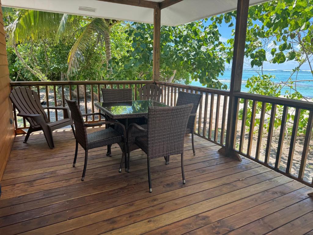 Parea的住宿－Parea Lodge Huahine Bungalow 1#MAHANA，甲板上配有桌椅的门廊