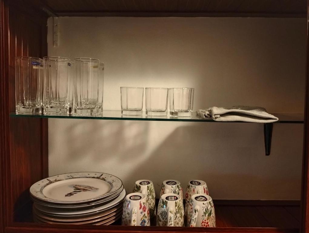 un estante con platos y vasos. en Grand Baie Holiday Apartment, en Grand Baie