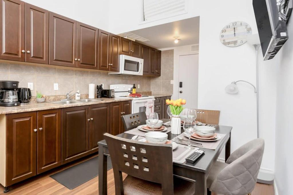 a kitchen with a table and chairs and a kitchen with a counter at Great Kensington Market 2BR Apartment in Toronto