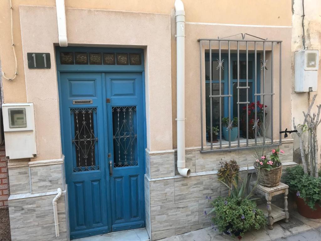 une porte bleue et une fenêtre sur un bâtiment dans l'établissement Casita bonita de pescador parking y sabanas en opción, à Almería