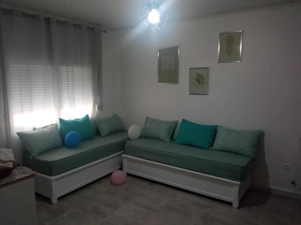 una sala de estar con 2 sofás en una habitación en Sweet 2 rooms accommodation, en Birkhadem