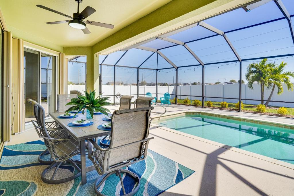un patio avec une table et des chaises à côté d'une piscine dans l'établissement Cozy Cape Coral Home 8 Mi to Marina!, à North Fort Myers