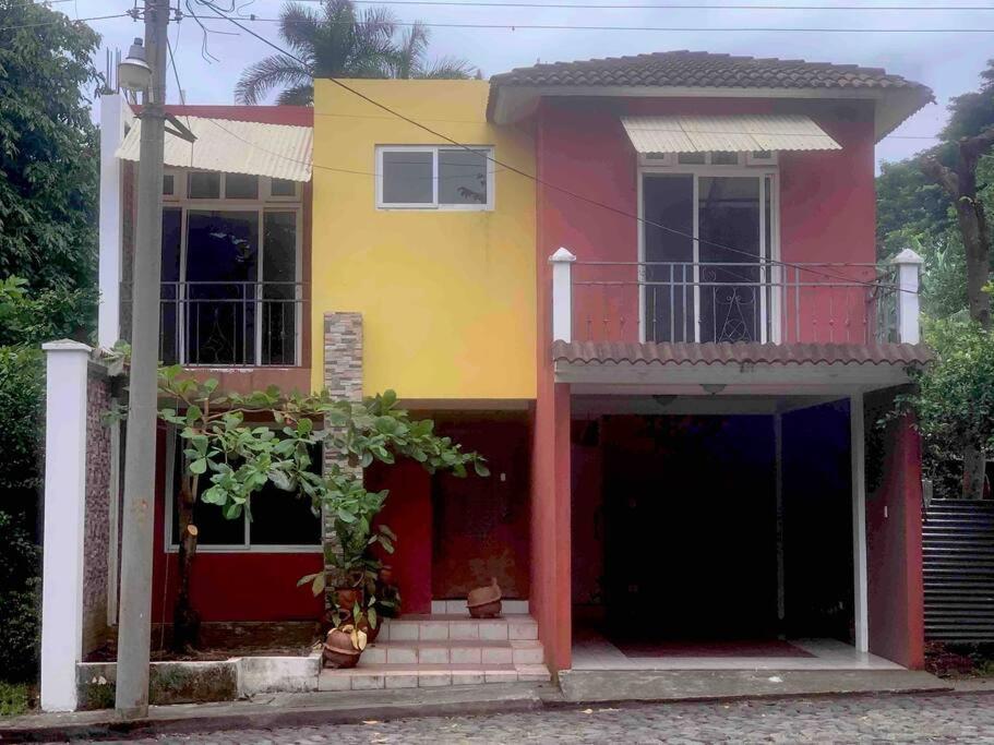 una casa de color rojo amarillo y blanco en Casa 4 a 5 minutos del IRTRA, en Retalhuleu