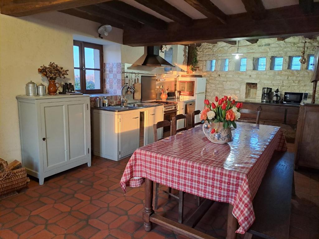 a kitchen with a table with a vase of flowers on it at La Chavoche in La Chapelle-de-Bragny