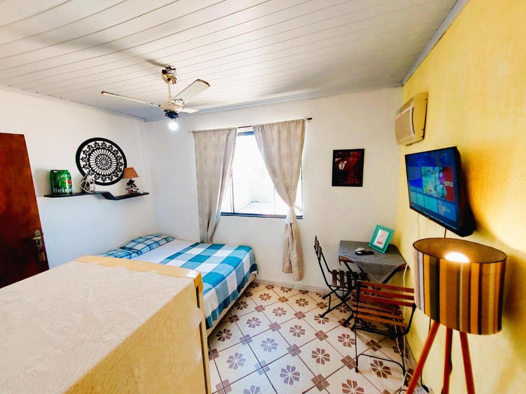 1 dormitorio con 1 cama y TV en Suítes do Renaldo 301, en Cabo Frío