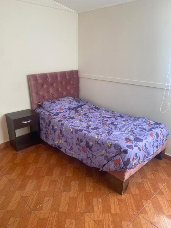 a bedroom with a bed with a purple comforter at Baquedano in Antofagasta