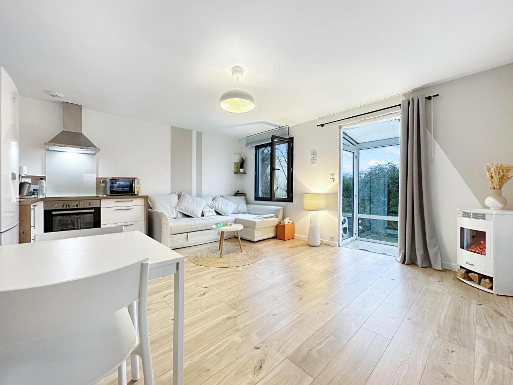 une cuisine et un salon avec un canapé et une table dans l'établissement La Pommedepin Ravissante maisonnette avec jardin, à Plouescat