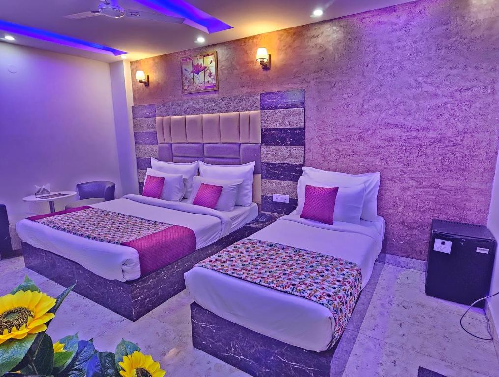 ニューデリーにあるHotel AMADA Infinity Near Delhi Airport By LA CASAの紫の壁のベッドルーム1室(ベッド2台付)