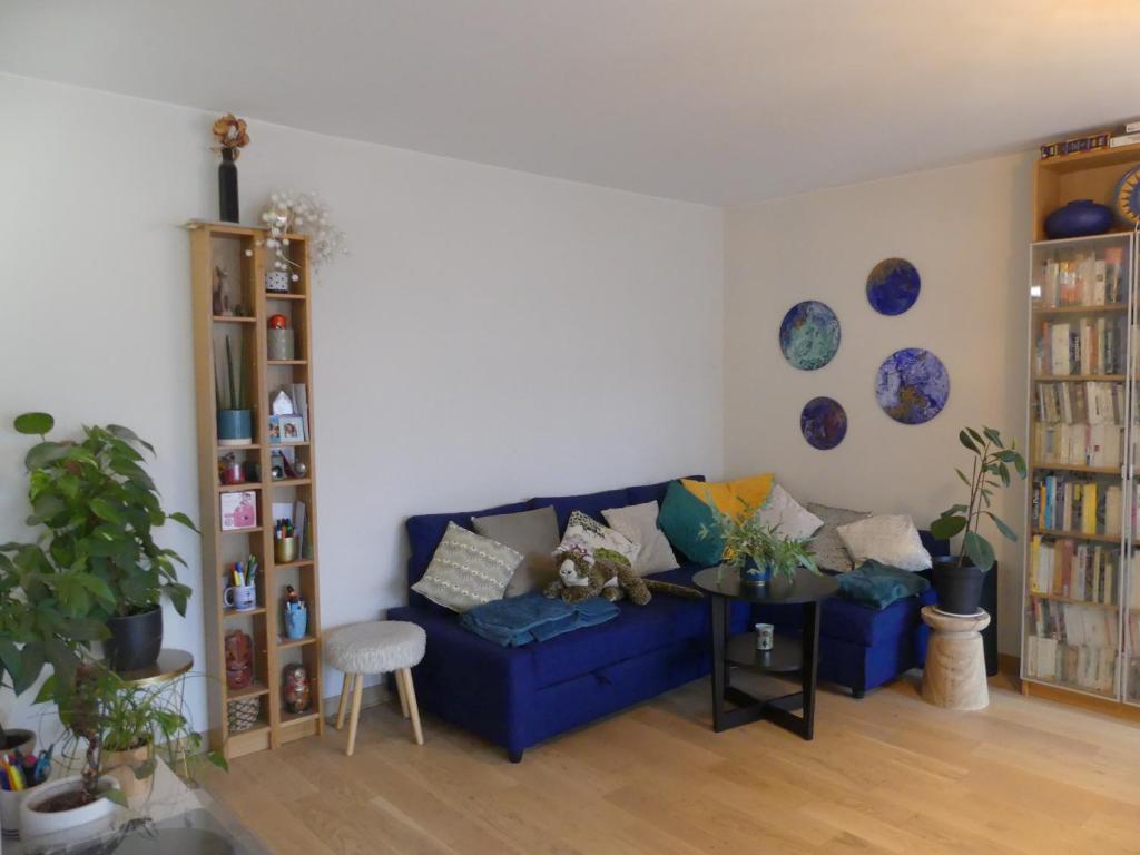 - un salon avec un canapé bleu et une table dans l'établissement Lovely room in quiet appartment, à Ivry-sur-Seine