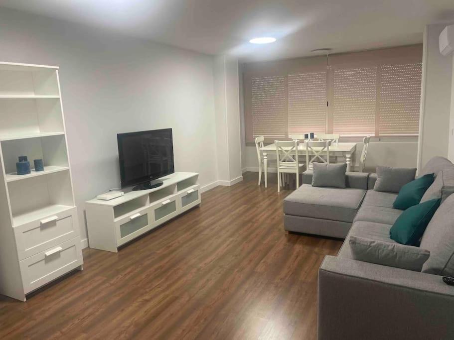ein Wohnzimmer mit einem Sofa, einem TV und einem Tisch in der Unterkunft Apartamento De lujo ! san juan pueblo, alicante in San Juan de Alicante