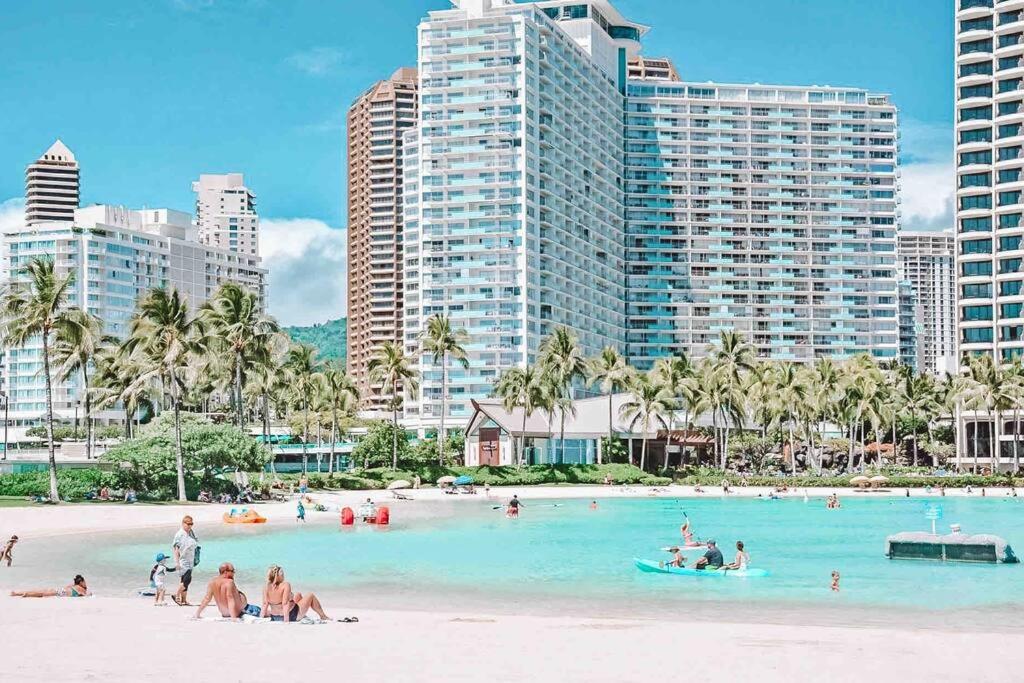 een groep mensen op een strand met hoge gebouwen bij Modern Luxury Large Studio in Honolulu