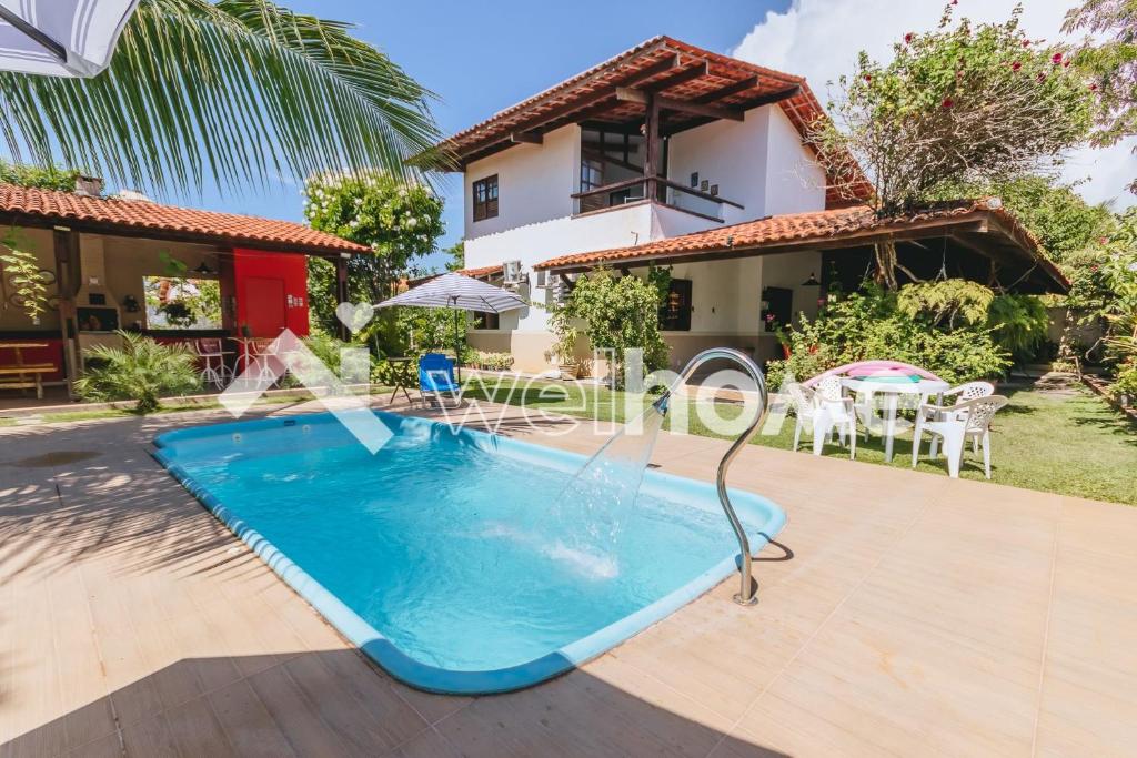 a swimming pool in front of a house at Casa com piscina a 5 min da praia em Alagoas in Barra de Santo Antônio