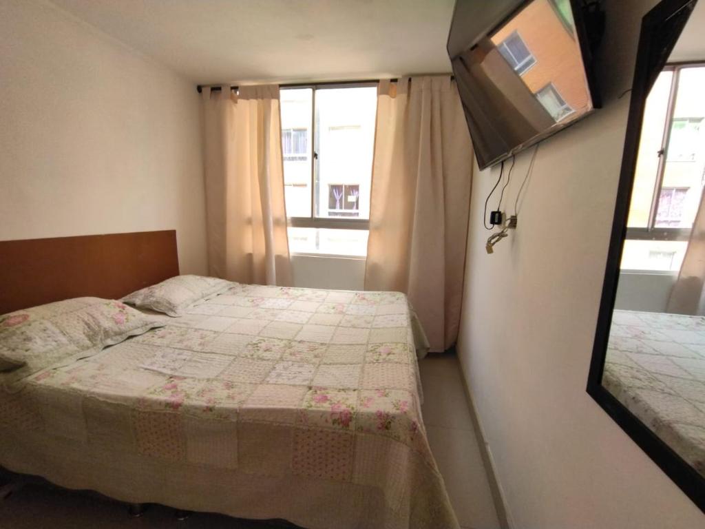 SoachaにあるTHE PIRAEUSの小さなベッドルーム(ベッド1台、壁掛けテレビ付)
