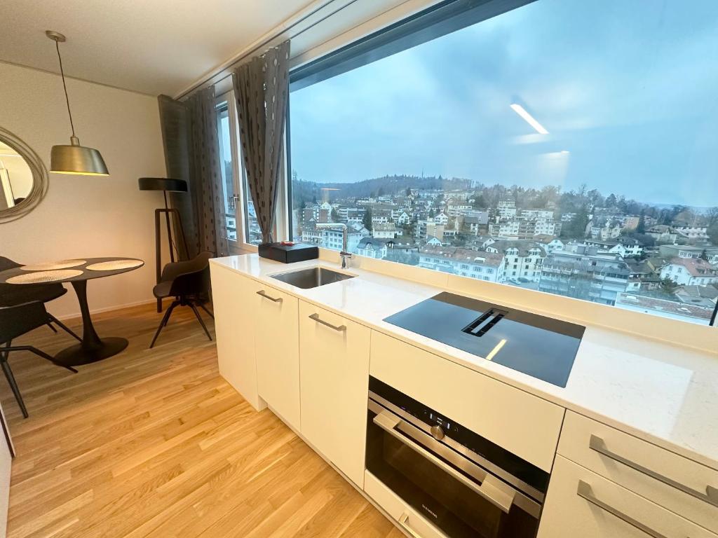 cocina con ventana grande con vistas a la ciudad en MydiHei @ Rhyfall Towers, en Neuhausen am Rheinfall