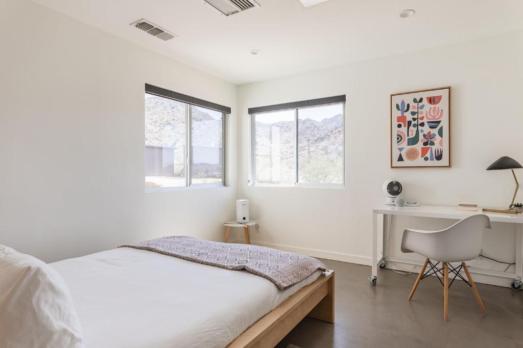 een witte slaapkamer met een bed en een bureau bij Highlands Retreat- Your Own Private Resort w Pool in Joshua Tree