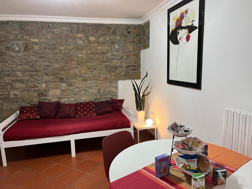 Domus Isidis room camera singola con cucina في بينيفنتو: غرفة معيشة مع أريكة حمراء وطاولة