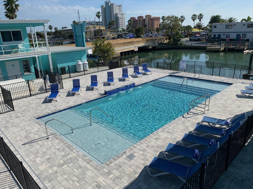 a swimming pool with blue lounge chairs and a swimming pool at Sea Jay Motel and Marina in St Pete Beach