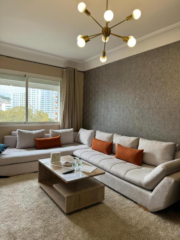 een woonkamer met een bank en een tafel bij Studio Plage Malabata tanger in Tanger