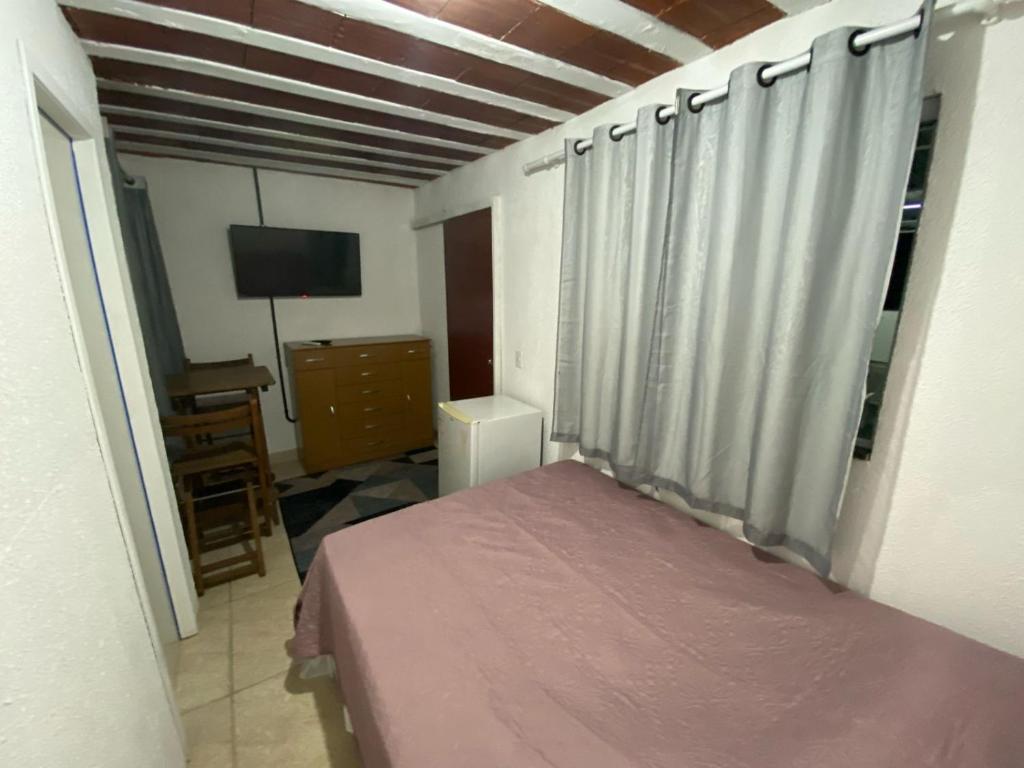 a bedroom with a bed and a television in it at Suite 3, Casa Amarela, Terceiro Andar in Nova Iguaçu