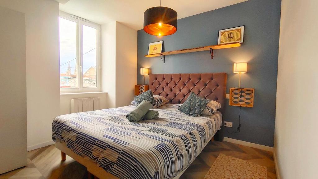 um quarto com uma cama com uma parede azul em Votre Escale - Magellan Cinéma em Niort