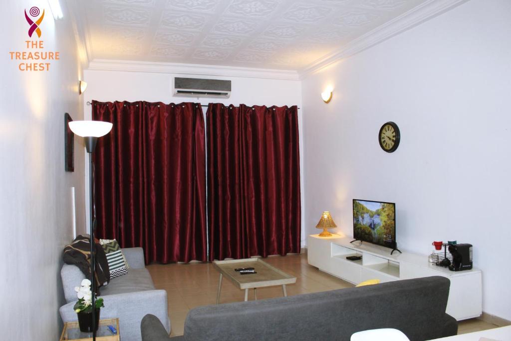 uma sala de estar com um sofá e cortinas vermelhas em Two Bedroom Villa at Ouagadougou em Ouagadougou