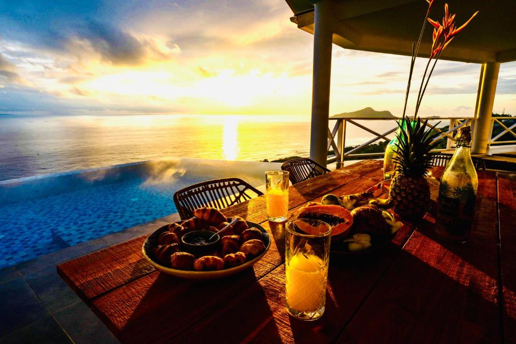 a table with a bowl of fruit and a bowl of juice at Villa Club Tropicana Carana with private infinity pool in Machabee