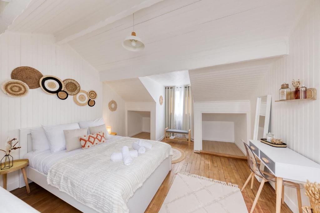 a white bedroom with a bed and a desk at Maison de ville triplex proche CDG in Sevran