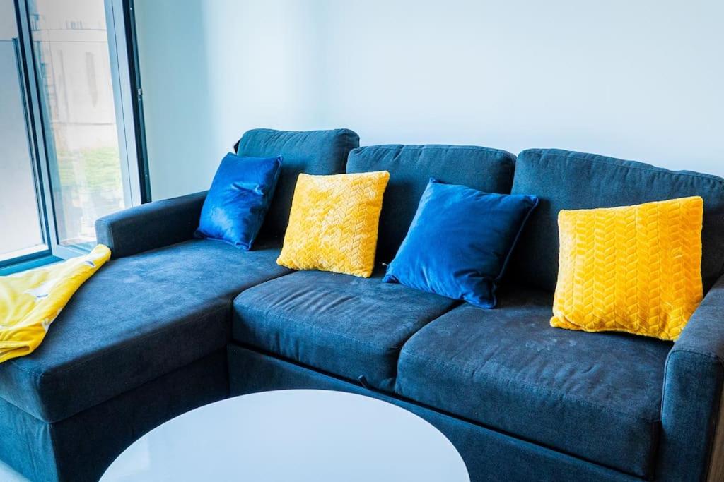 a blue couch with blue and yellow pillows on it at 30% Off Monthly Stay/2Bed House - Sittingbourne in Kent