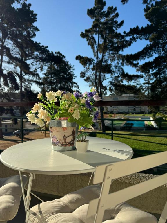 a white table with a vase of flowers on it at Desconexión, tranquilidad y disfrute en El Tabo in El Tabo