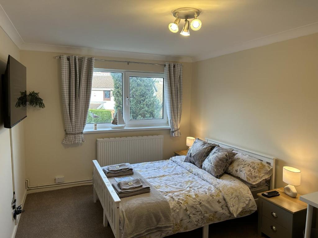 um quarto com uma cama e uma janela em 35 Southerndown Avenue em Swansea