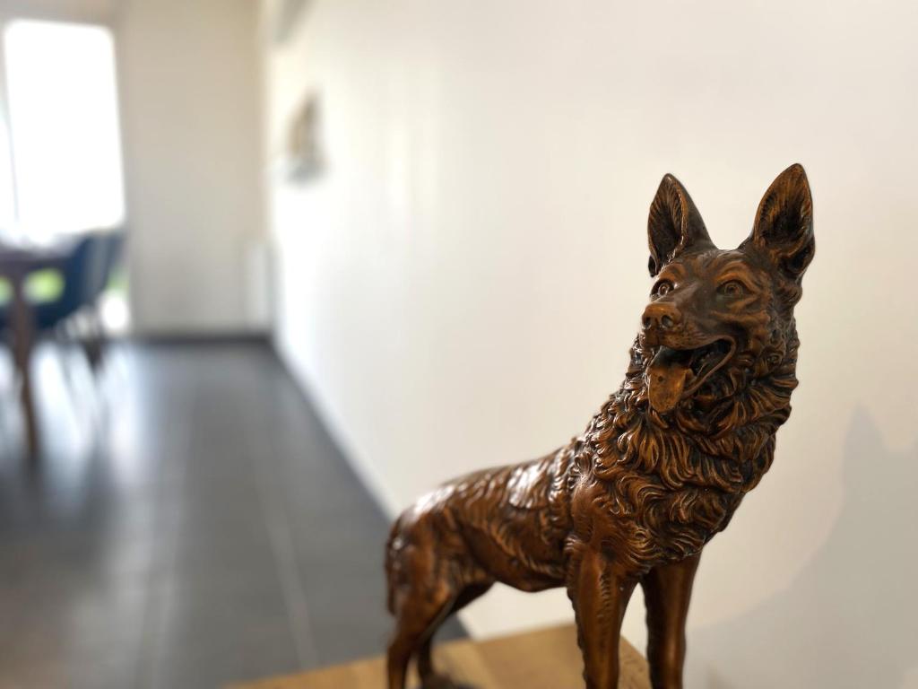 a small statue of a dog sitting on a table at La belle des champs in Luzillé
