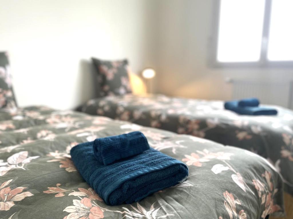 a blue towel sitting on the end of a bed at La belle des champs in Luzillé