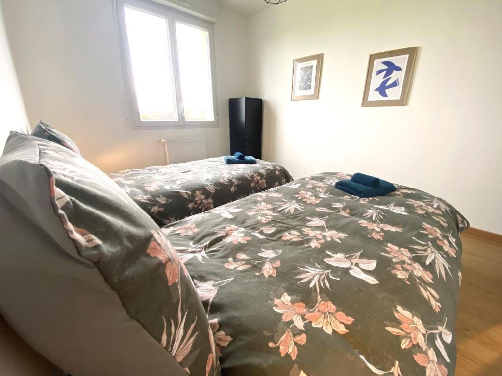 a bedroom with a bed with a floral bedspread at La belle des champs in Luzillé