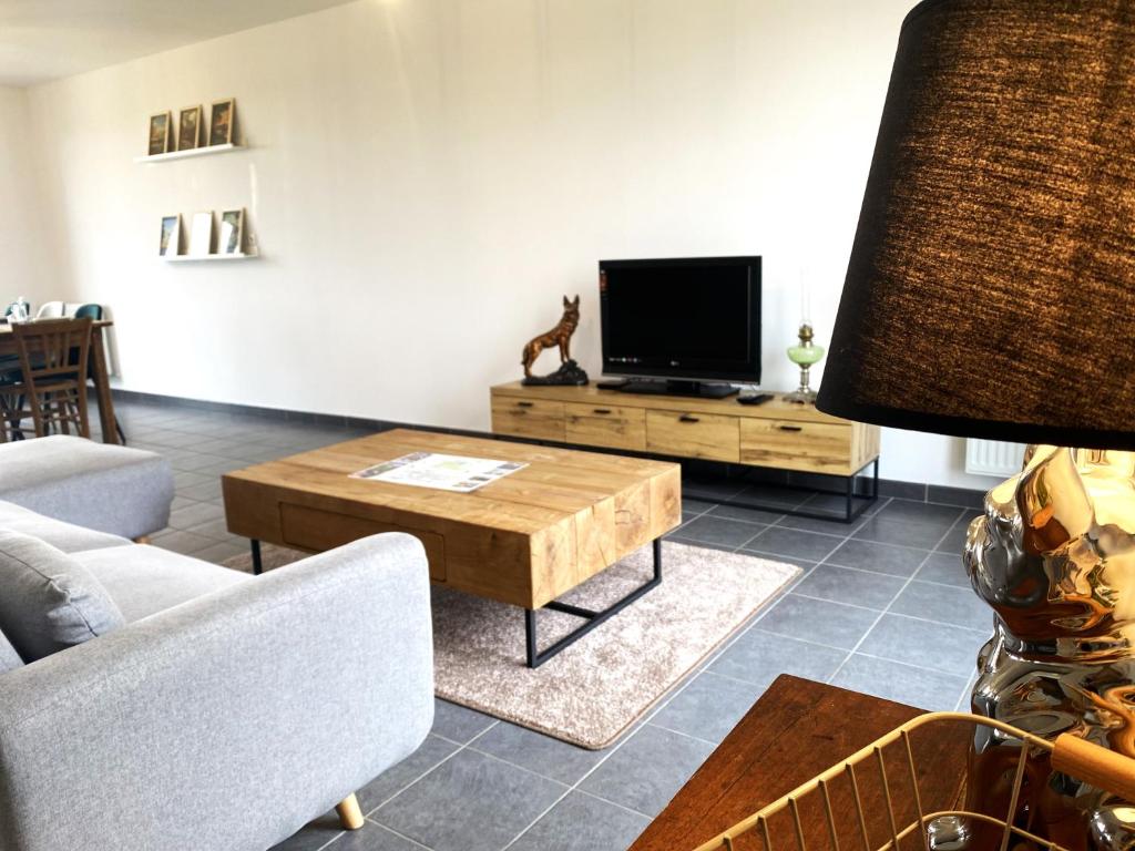 a living room with a television and a coffee table at La belle des champs in Luzillé